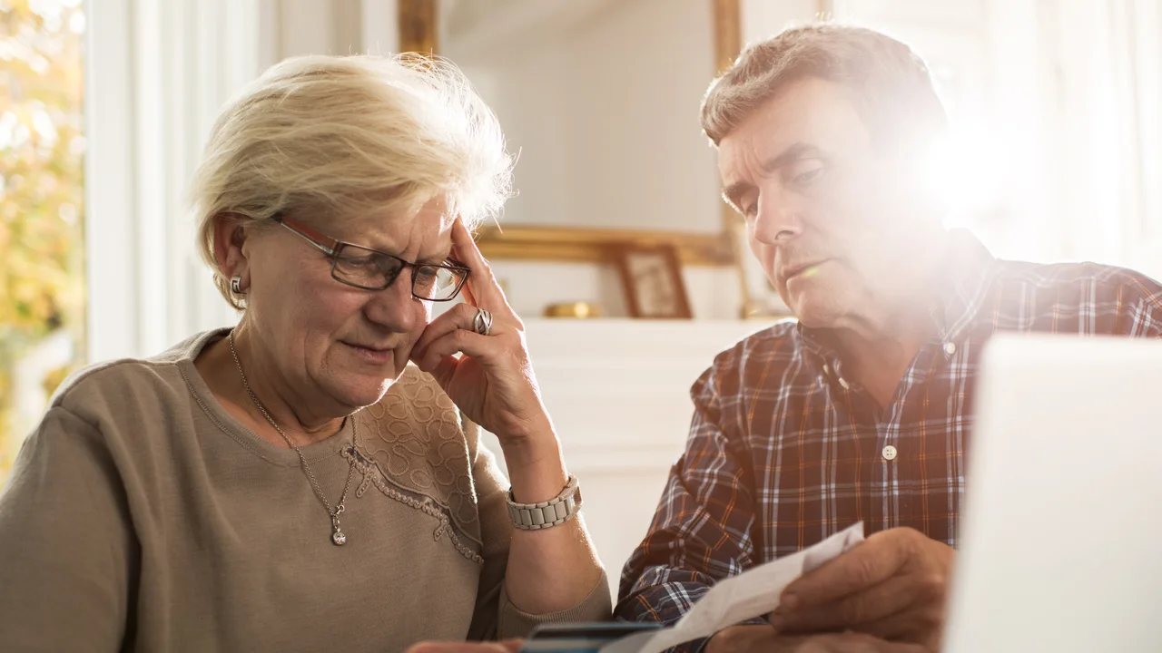 blue bowl of black bean beef tortilla soup on a board with cilantro and shredded cheese in background