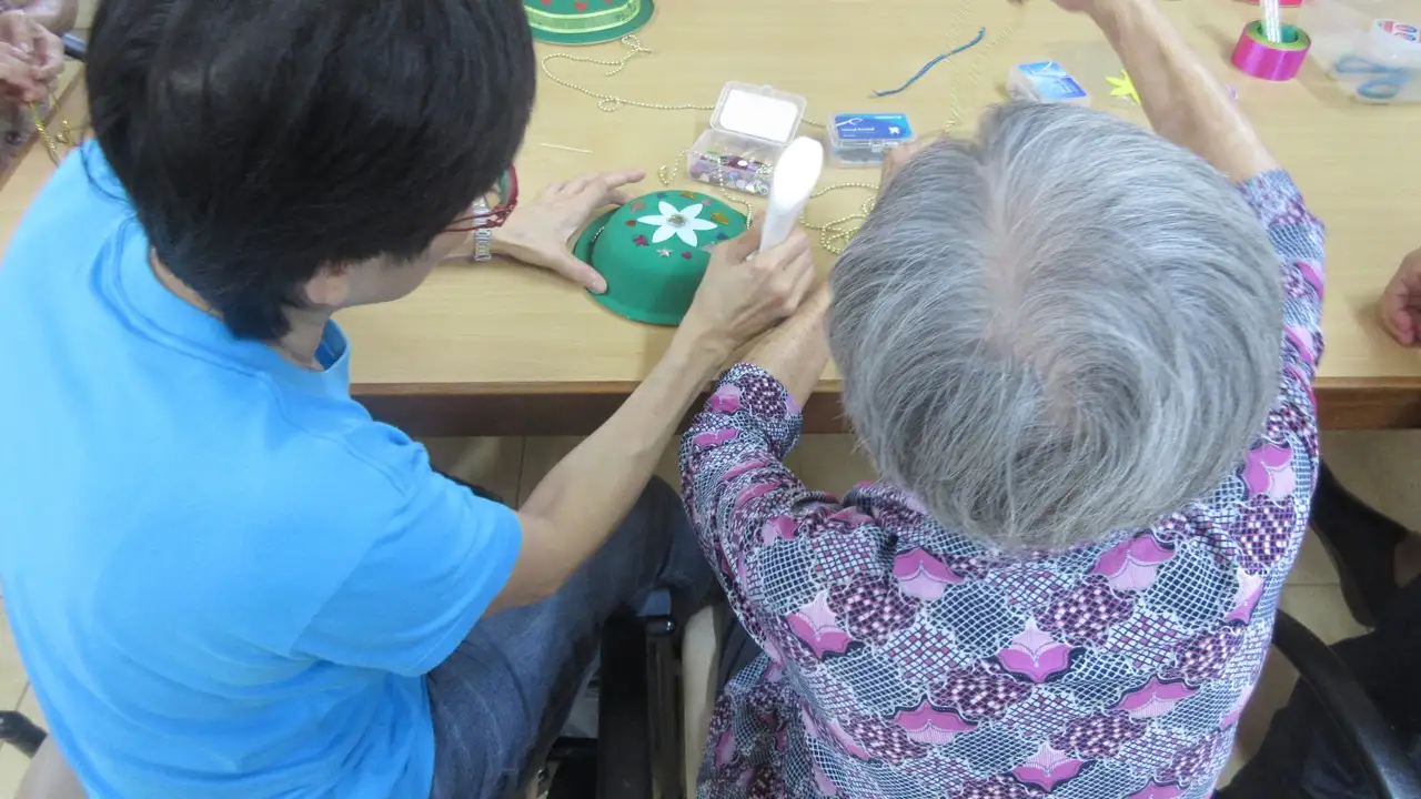 Close up on a plate of mashed potatoes, topped with baked pork chops with cream of mushroom soup, and a side of green beans.