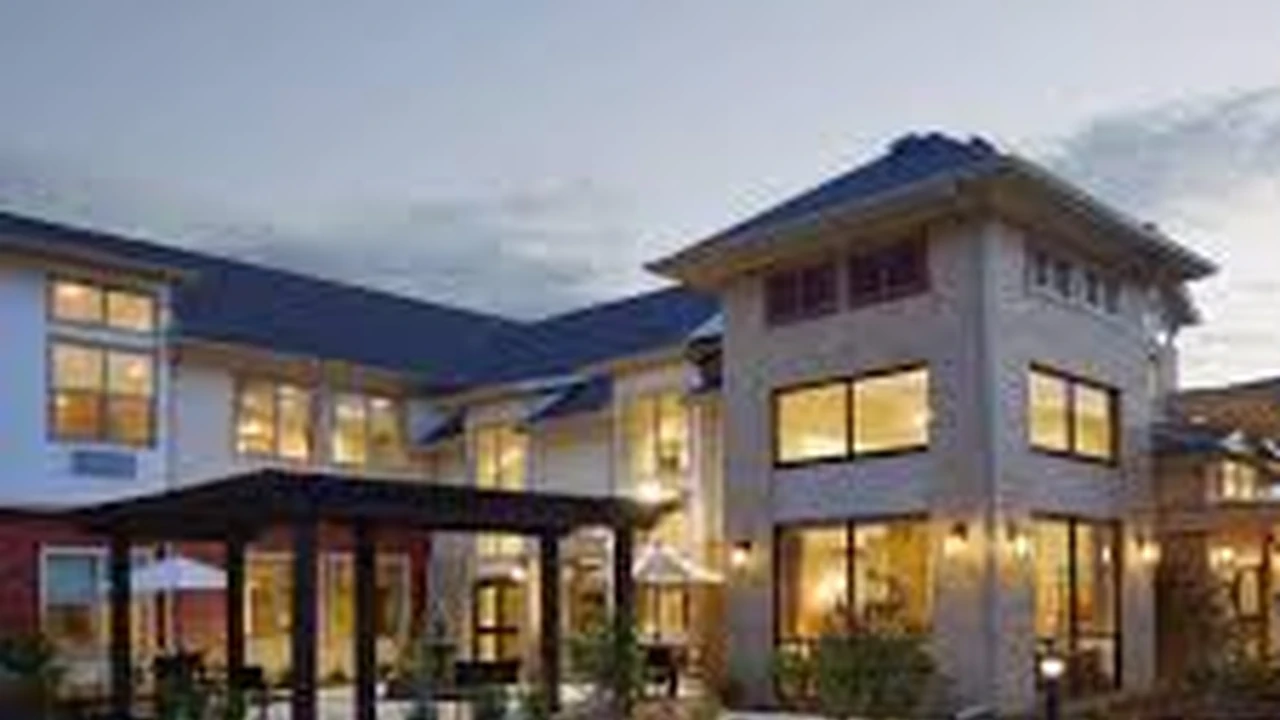 Close up on a plate of mashed potatoes, topped with baked pork chops with cream of mushroom soup, and a side of green beans.