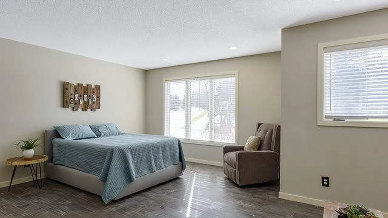 Close up on a plate of mashed potatoes, topped with baked pork chops with cream of mushroom soup, and a side of green beans.